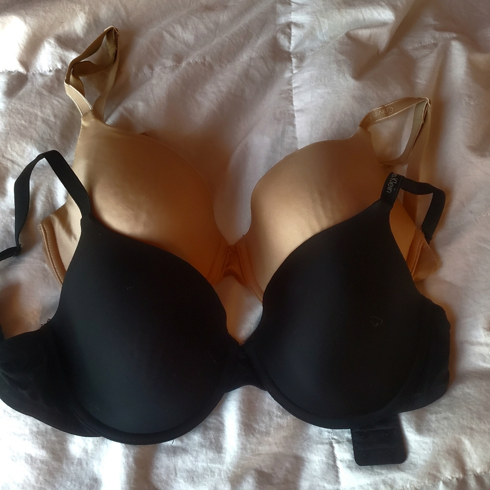 A black and a beige Calvin Klein bra